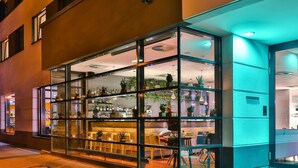 A modern building with a glass facade, interior plants, and a seating area visible through the windows. - Hotel Frankfurt Messe affiliated by Meliá (Frankfurt)