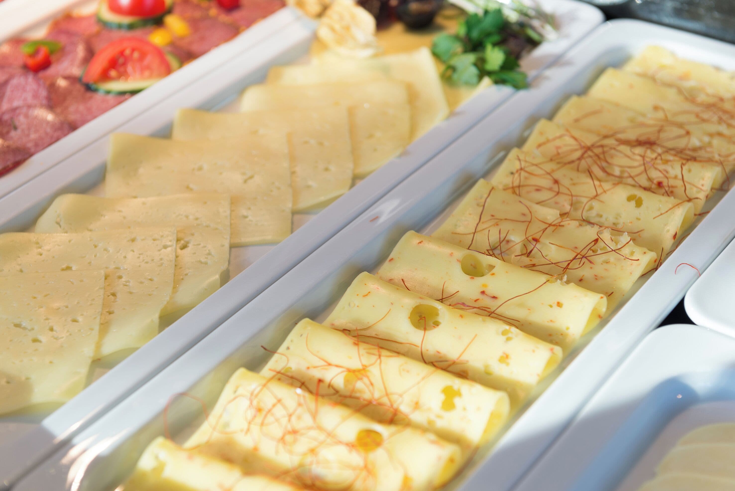 Un bufé con diferentes opciones de comida, como embutidos, quesos y platos decorados.