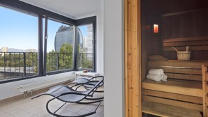 A modern room with large windows, a sauna, and a view of a cityscape. - Hotel Frankfurt Messe affiliated by Meliá (Frankfurt)