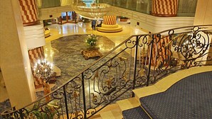 A grand lobby with a marble floor, a central fountain, and a staircase with ornate railings. - Grand Hotel La Pace (Sant'Agnello)