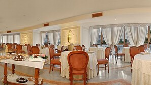 Un comedor amplio con varias mesas y sillas, dispuestas en una distribución simétrica.