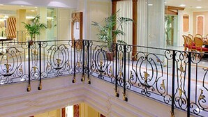 A hotel lobby with a red carpet, multiple seating areas, and a glass railing. - Grand Hotel La Pace (Sant'Agnello)