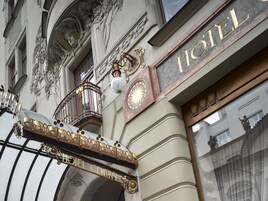 Segnaletica di un hotel con la scritta 'HOTEL CENTRAL' e un balcone con decorazioni in metallo elaborate.