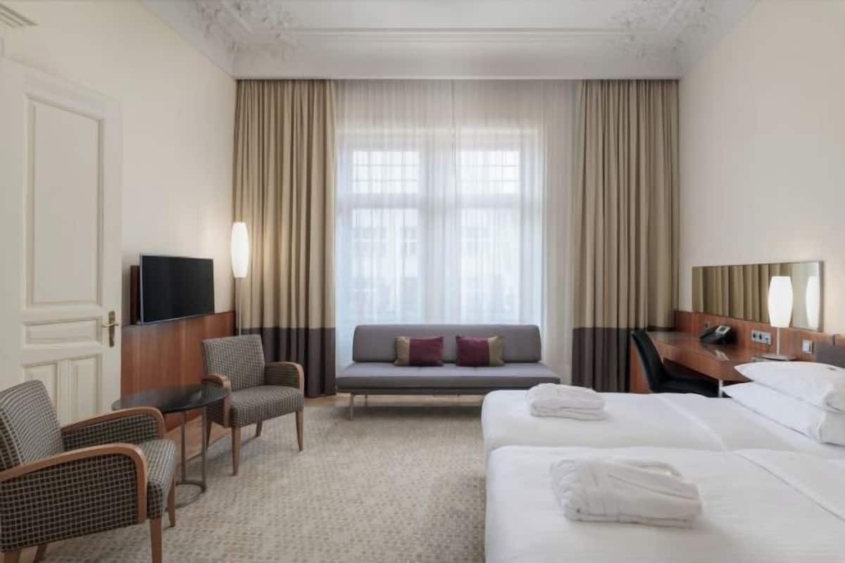 Ropa de cama hipoalergénica y caja de seguridad en la habitación