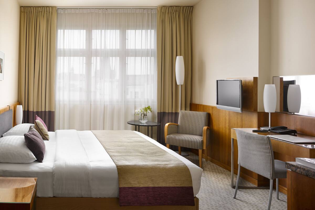 Ropa de cama hipoalergénica y caja de seguridad en la habitación