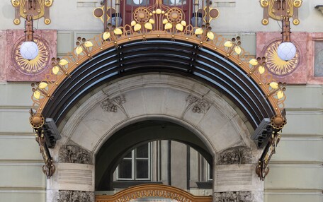 An ornate entrance with a black archway, two potted plants, and a sign reading "KK Hotel Central".