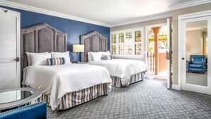 Une chambre d’hôtel avec deux lits, une table ronde et une chaise.