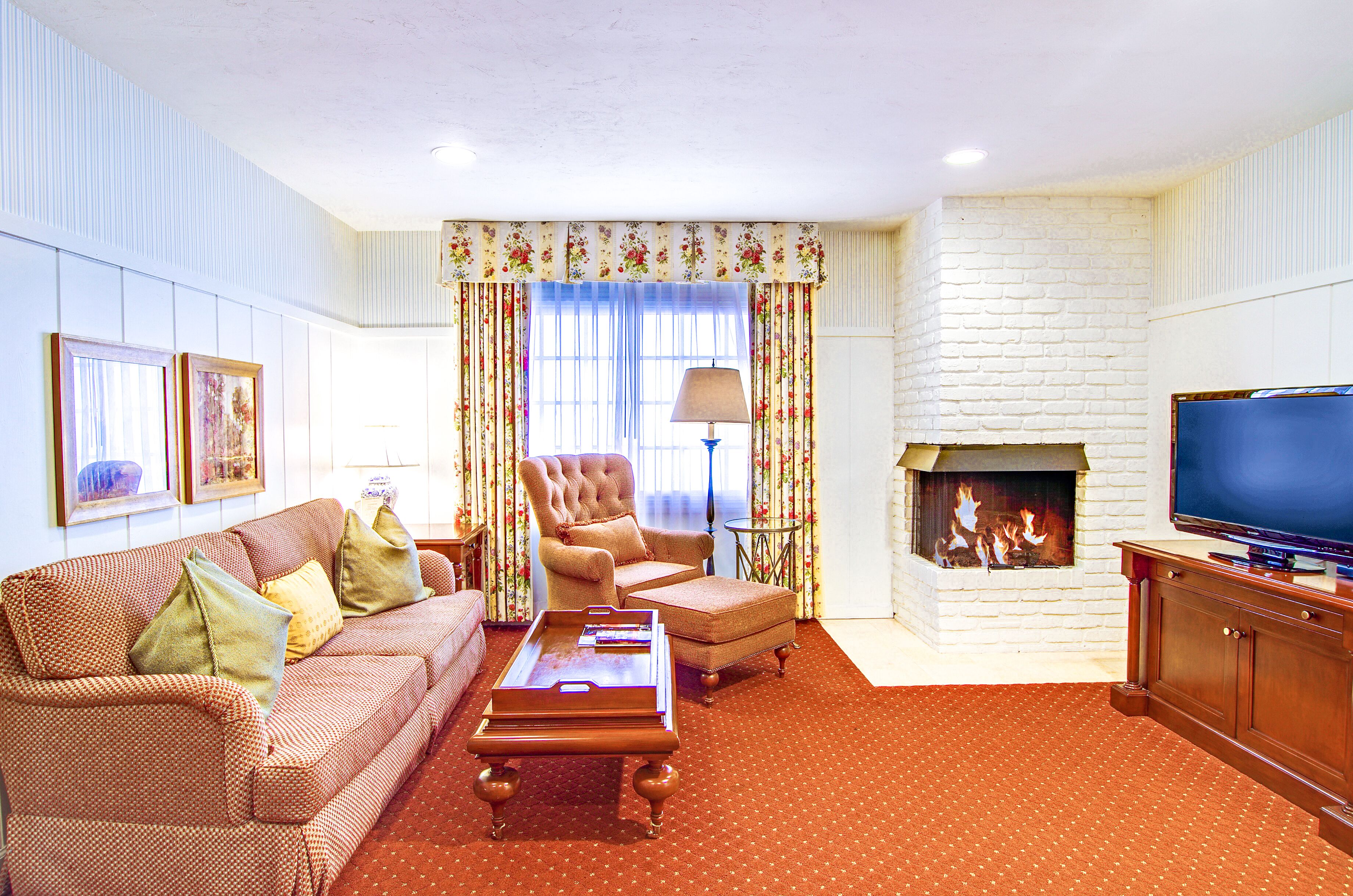 standard suite, 1 king bed, fireplace | living area | flat-screen tv