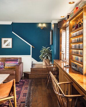 A cozy living room with a staircase, a bookshelf, and a coffee table.