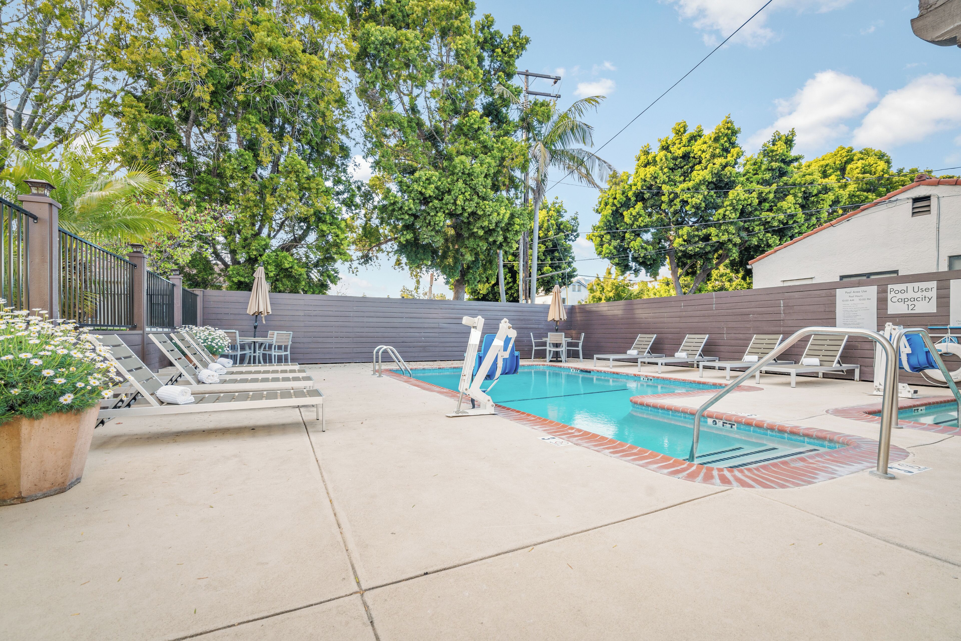 A swimming pool with lounge chairs and a lifeguard stand.