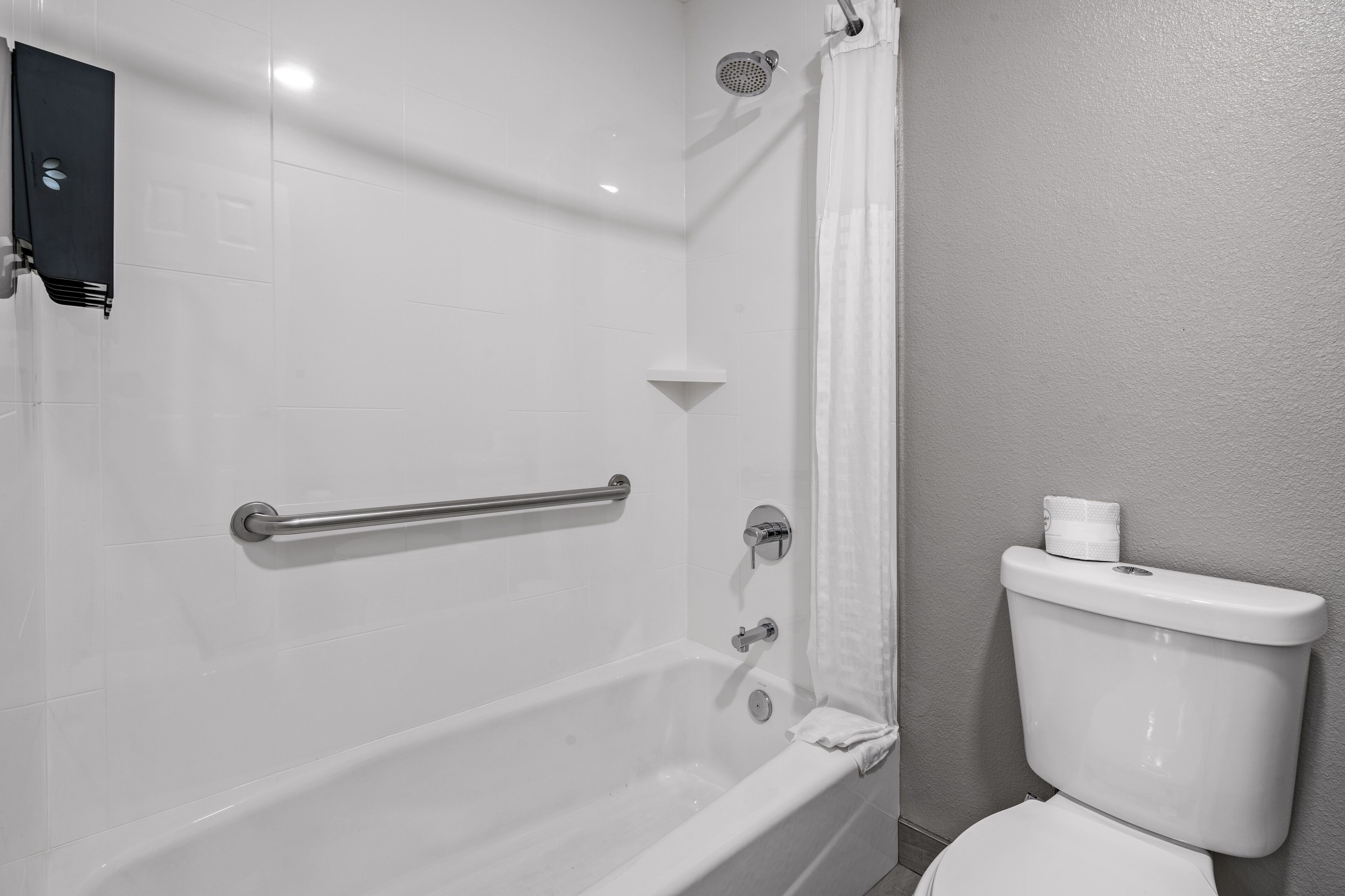 A bathroom with a bathtub, a toilet, and a shower curtain.