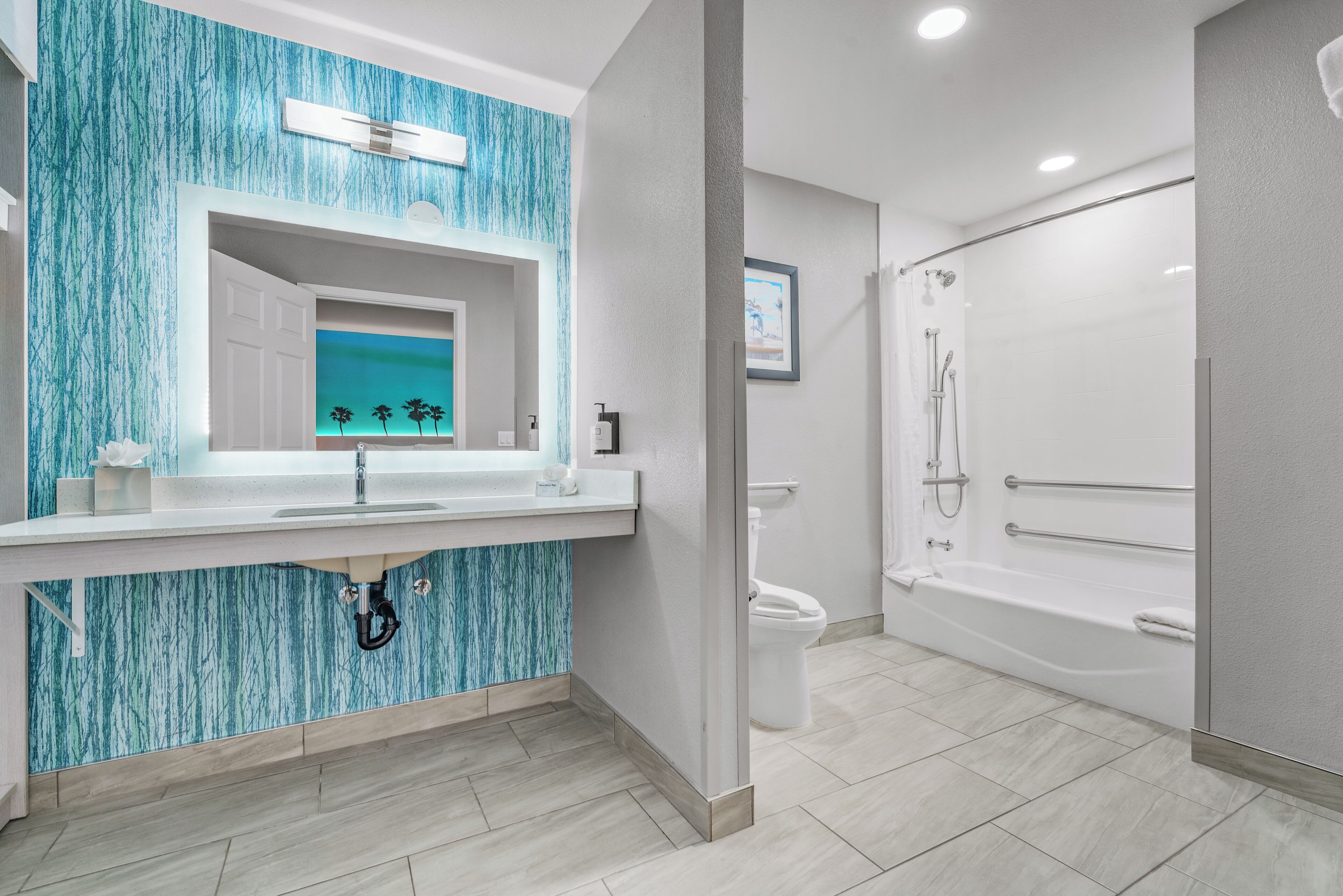 A modern bathroom with a large mirror, a sink, and a walk-in shower.