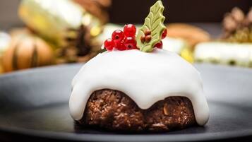 Un postre con glaseado blanco y bayas rojas sobre un plato.