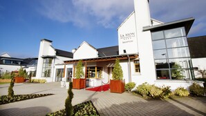 A modern hotel with a reception area, large windows, and a well-maintained garden. - La Mon Hotel And Country Club (Newtownards)