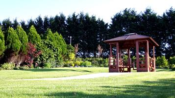 Escape to a serene natural oasis with a tranquil gazebo nestled among lush trees and a well-manicured lawn.