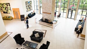 A spacious lobby with a stone fireplace, comfortable seating, and large windows offering views of the outdoors. - La Mon Hotel And Country Club (Newtownards)