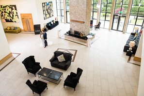 A spacious lobby with a stone fireplace, comfortable seating, and large windows offering views of the outdoors. - La Mon Hotel And Country Club (Newtownards)