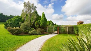 A pathway leading through a well-maintained garden with various shrubs and trees. - La Mon Hotel And Country Club (Newtownards)