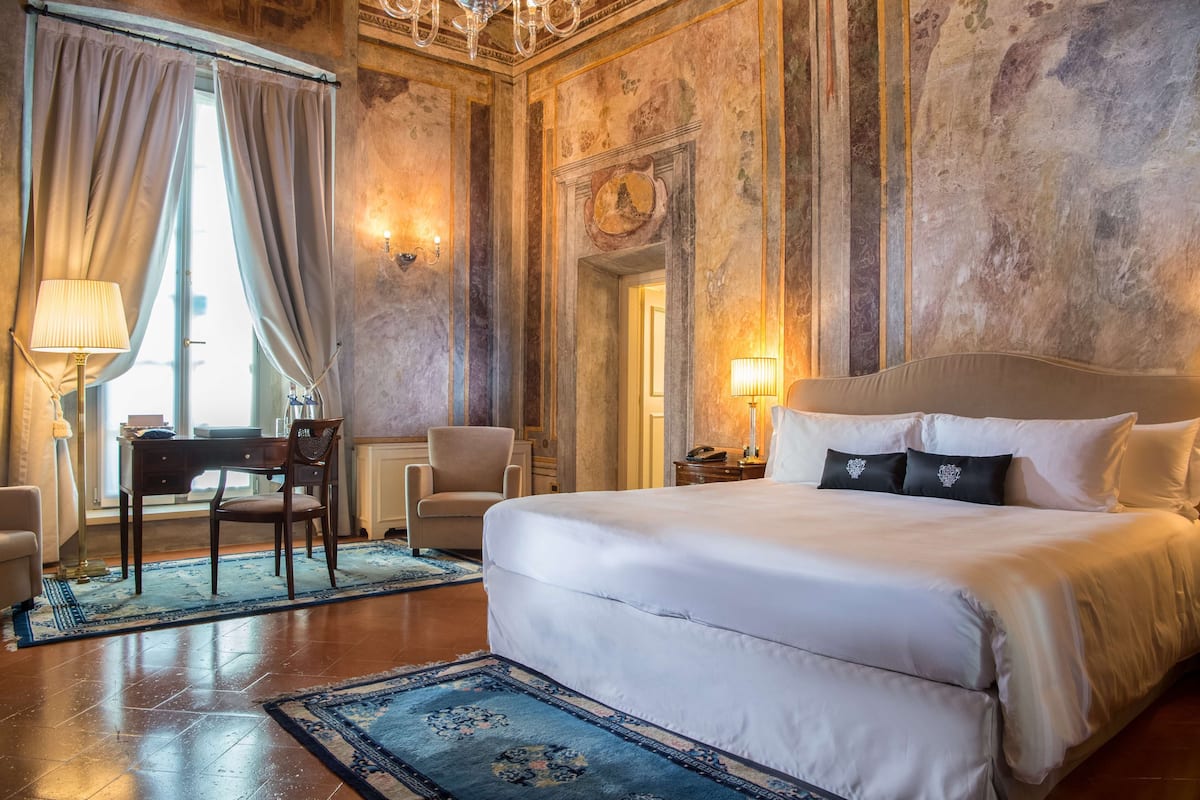 Ein Hotelzimmer mit einem großen Bett, einem Schreibtisch und einem Stuhl.