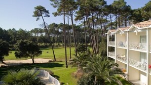 A hotel with a balcony overlooking a golf course. - Madame Vacances Résidence Du Golf (Moliets-et-Maa)