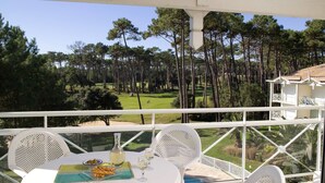 A balcony with a table set for two, overlooking a golf course. - Madame Vacances Résidence Du Golf (Moliets-et-Maa)