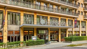 A hotel with a modern facade, a prominent 'Hyperion' sign, and a well-maintained entrance area with a small garden. - HYPERION Hotel Berlin (Berlin)
