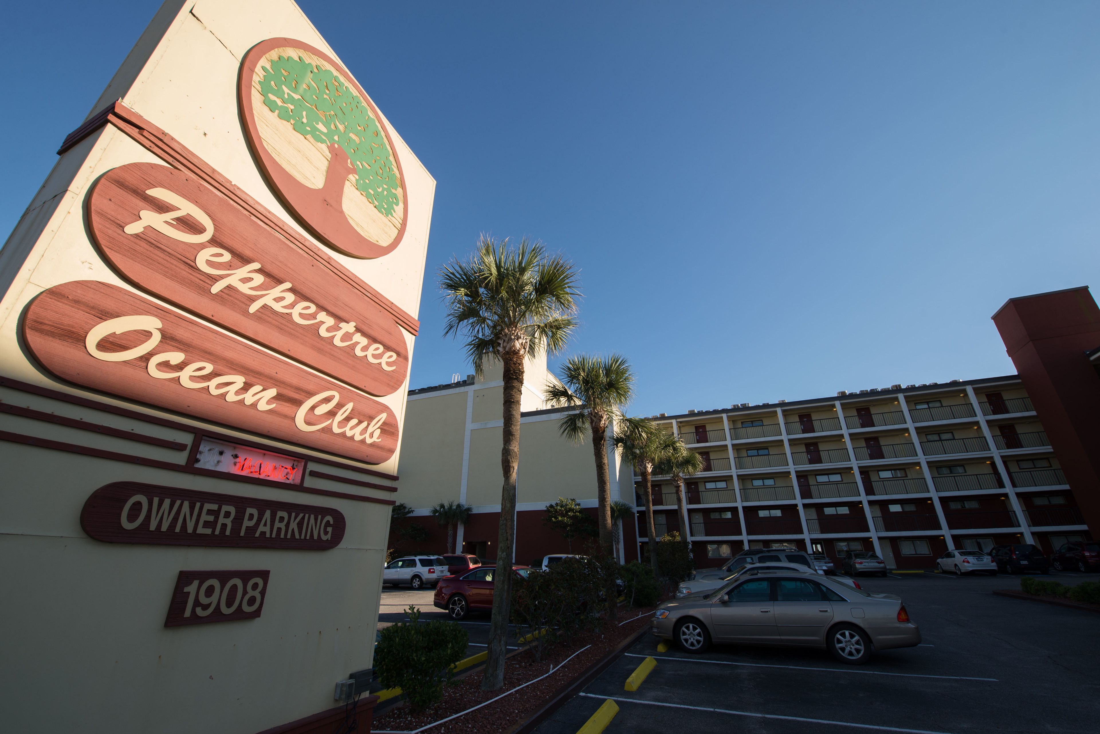 A hotel sign with a tree logo and the name "Peppertree Ocean Club".