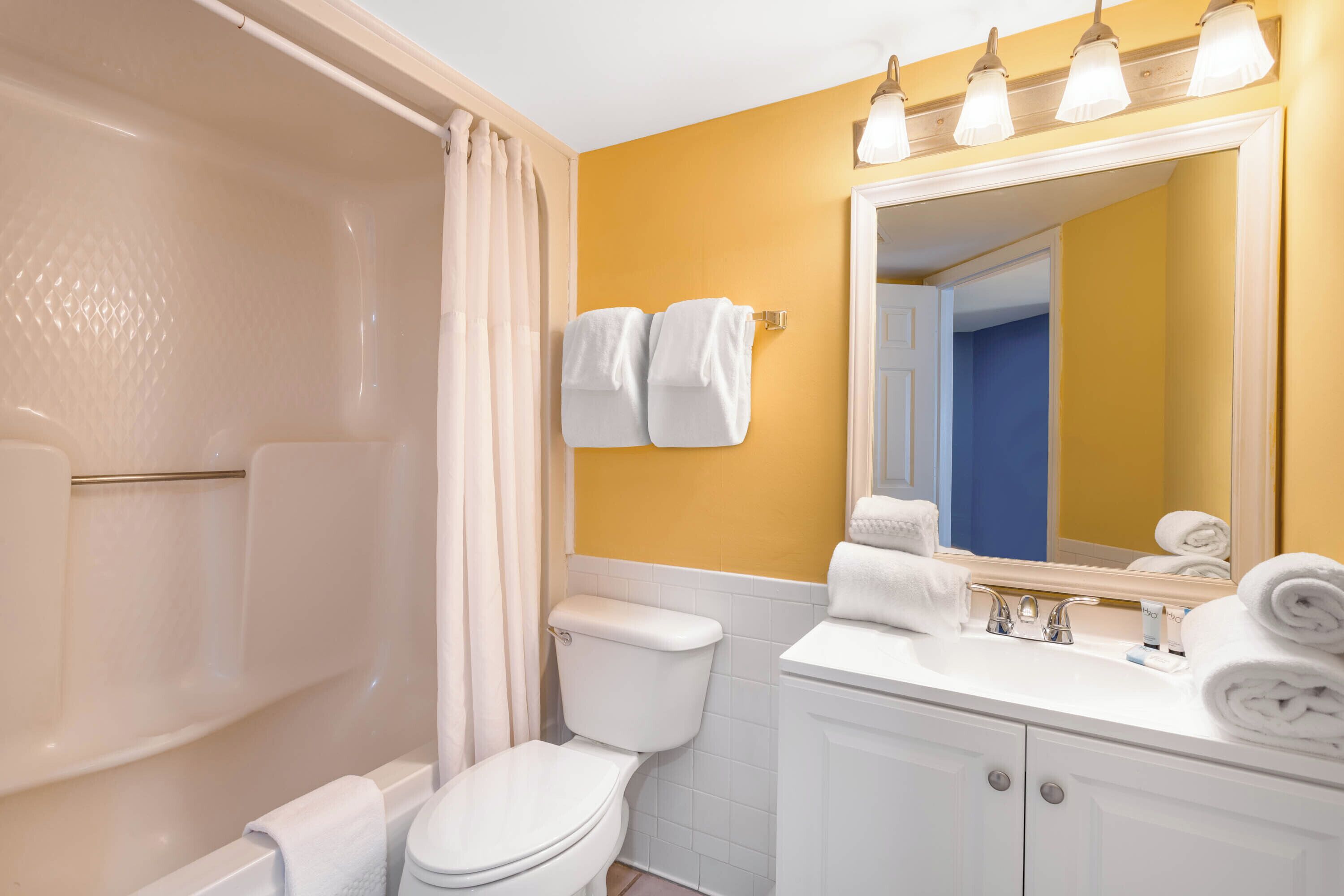 A bathroom with a bathtub, toilet, and sink.