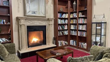 A cozy living room with a fireplace, bookshelves, and comfortable seating.