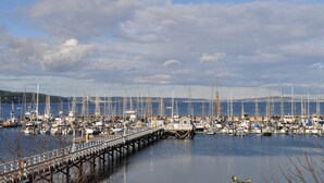 A marina with numerous boats docked, a wooden pier, and calm water. - Old Alcohol Plant Hotel (Port Hadlock)