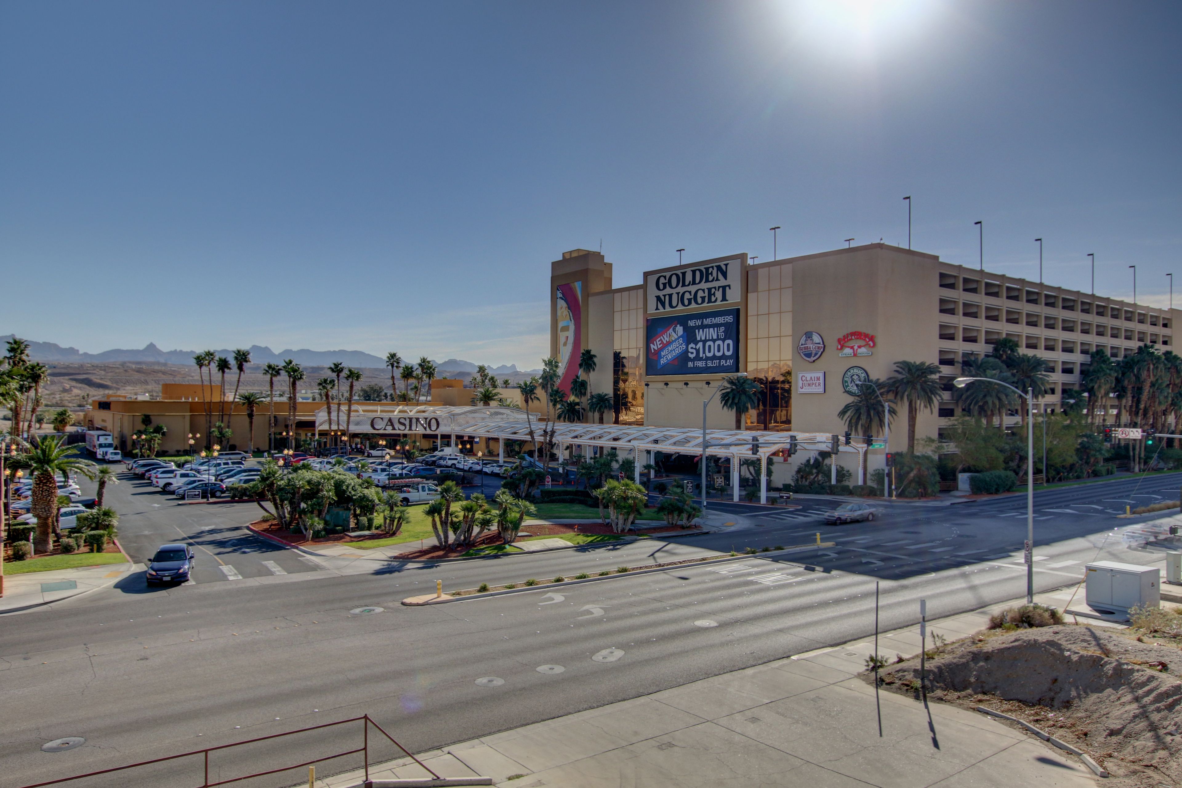A casino complex with a prominent Golden Nugget sign, multiple parking lots, and a clear view of the surrounding desert landscape.