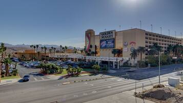 Un complexe hôtelier comprenant un casino, un grand panneau publicitaire avec l’inscription « Golden Nugget », plusieurs parkings et une vue dégagée sur le paysage désertique environnant.