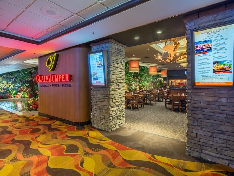 A restaurant with a sign reading "Claim Jumper" and a menu board displaying various dishes.