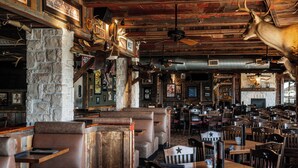 A restaurant with booths, tables, and a rustic decor including antlers and a fireplace. - Golden Nugget Laughlin (Laughlin)
