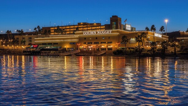 Un hotel con un llamativo letrero de 'Golden Nugget' que se refleja en el agua.