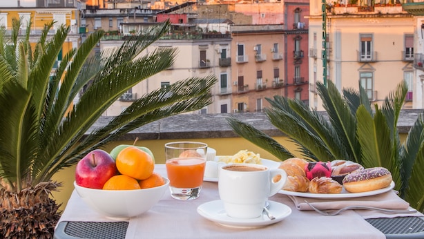Una mesa con alimentos para el desayuno y vistas a la ciudad.
