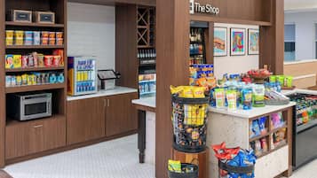 A snack kiosk with various packaged snacks and a microwave.