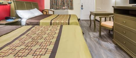A hotel room with two beds, a desk, a chair, a dresser, a television, and a window with curtains.