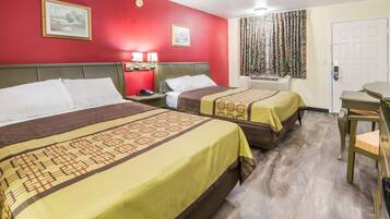 A hotel room with two beds, a desk, and a chair.