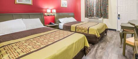 A hotel room with two beds, a desk, and a chair.