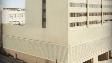 A multi-story building with a flat facade, large windows, and a parking garage.