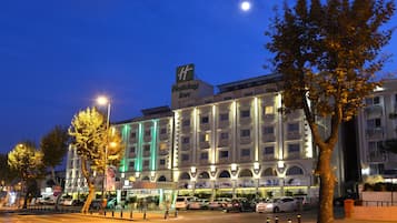Classic hotel exterior with a symmetrical facade and prominent sign.