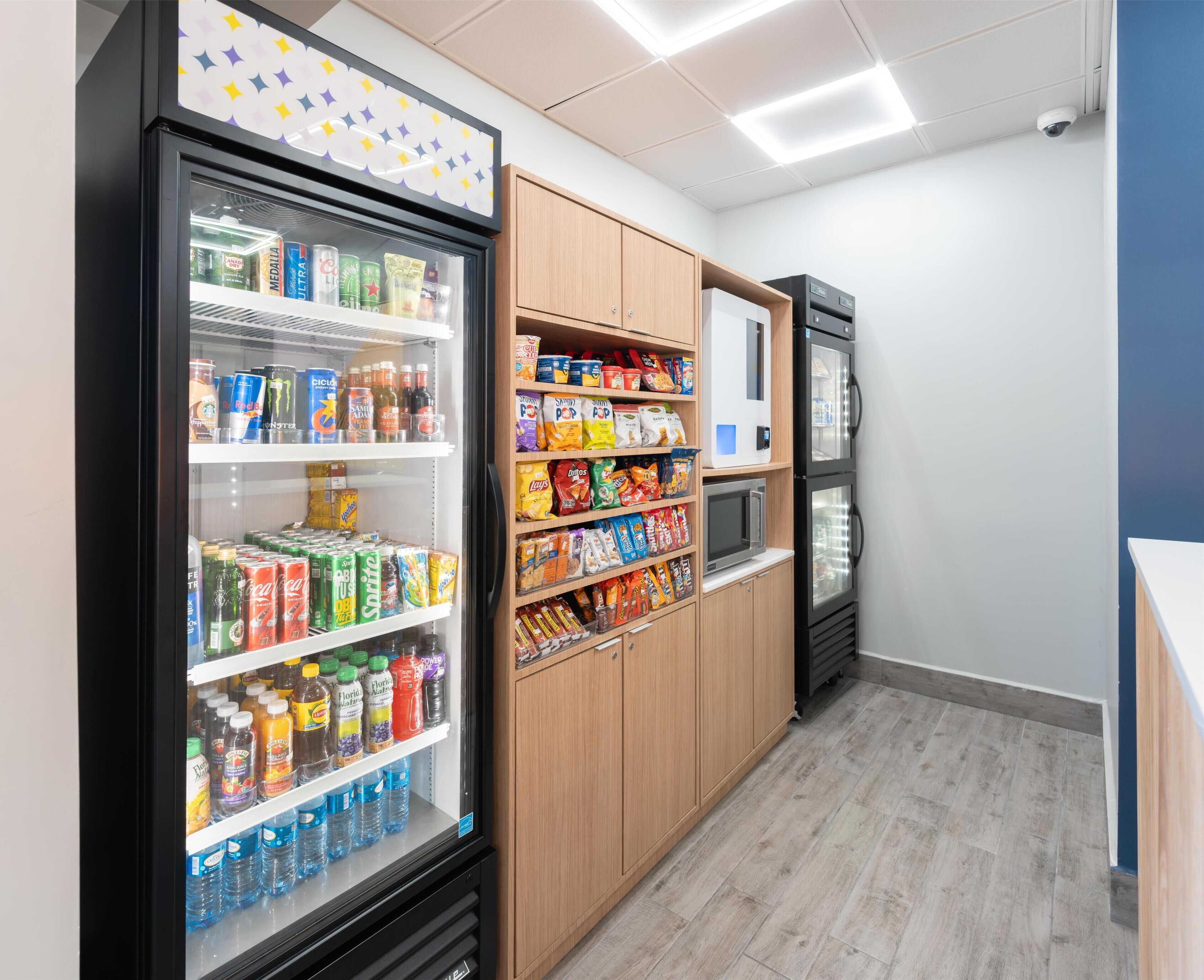 Un área de venta con refrigeradores de bebidas y estantes para snacks.
