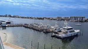 A marina with boats docked, a wooden pier, and buildings in the background. - Inn on Destin Harbor, an Ascend Collection Hotel (Destin)