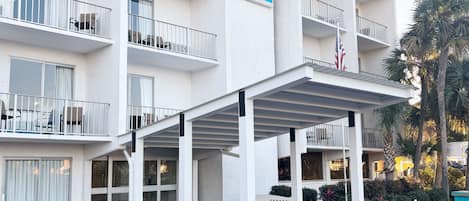 Un hotel de varios pisos con balcones, una entrada cubierta y un cartel que indica que es The Inn at Destin Harbor.