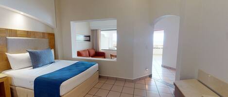 A hotel room with a bed, a nightstand, a red chair, and a view of the balcony.