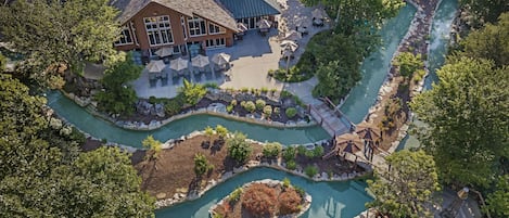 Oversigtsbillede af et resort med en swimmingpool, en træterrasse og en bygning med udendørs siddepladser.
