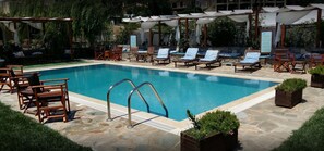 Una piscina al aire libre de temporada, sombrillas