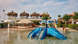 A water park with a blue slide and thatched-roof structures. - Gloria Verde Resort - All Inclusive (Serik)