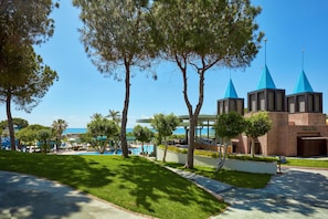 A resort with a swimming pool, a covered patio, and a view of the ocean.